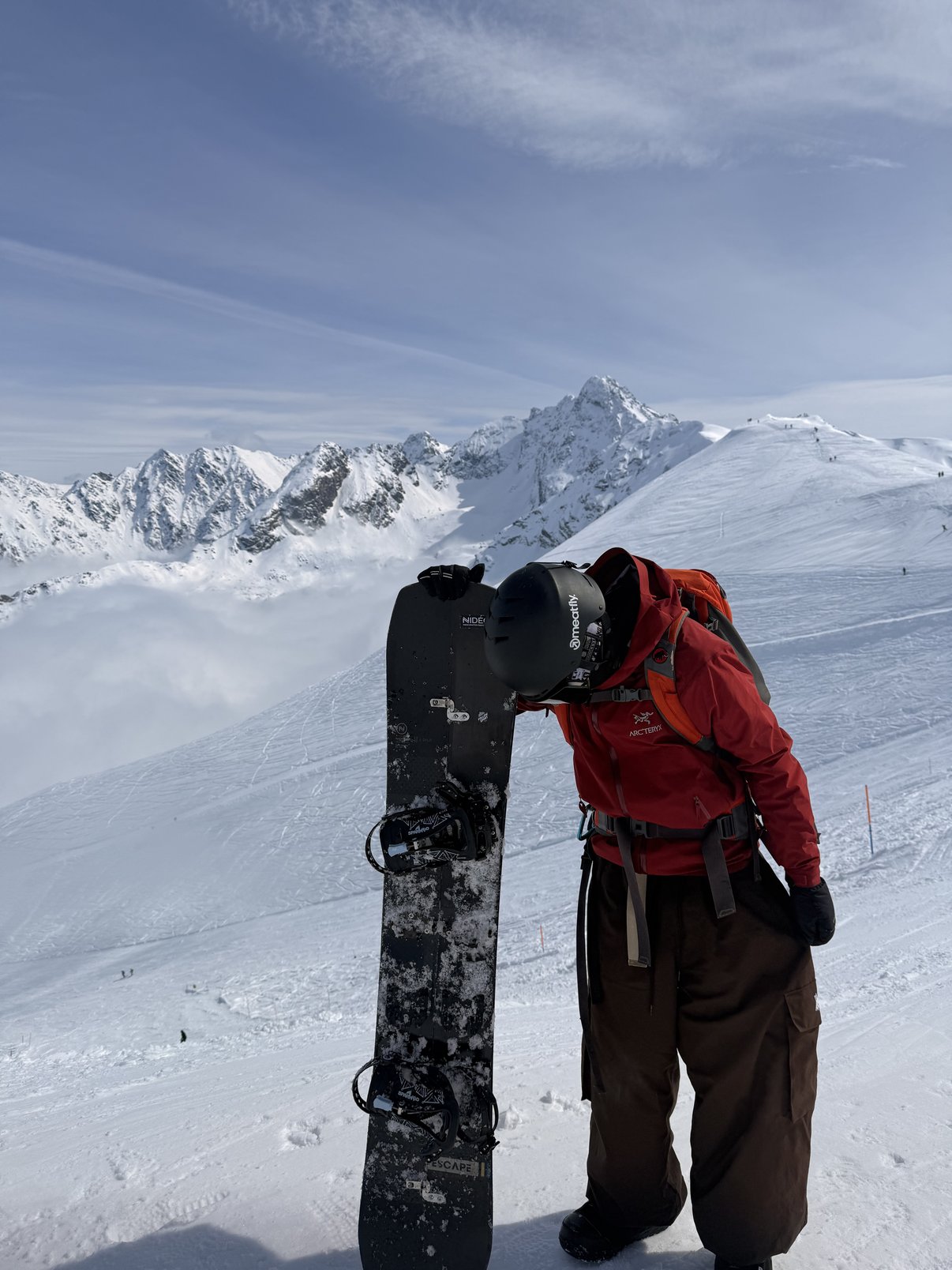 Odpoczynek na desce snowboardowej nad morzem chmur w górach